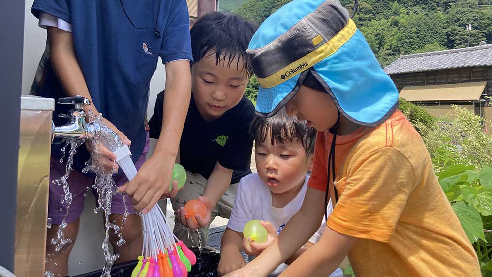 風船に水を入れて遊ぶこどもたち。敷地内でもいろいろな遊びができます。