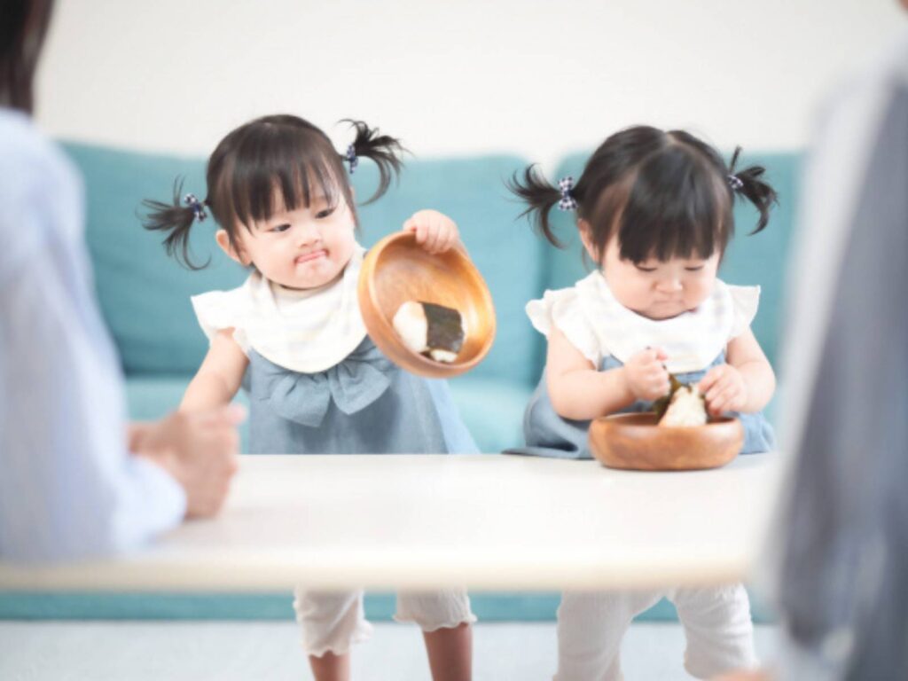 食べものが入っているボウルを触りながら、食の探索をしている二人の子ども