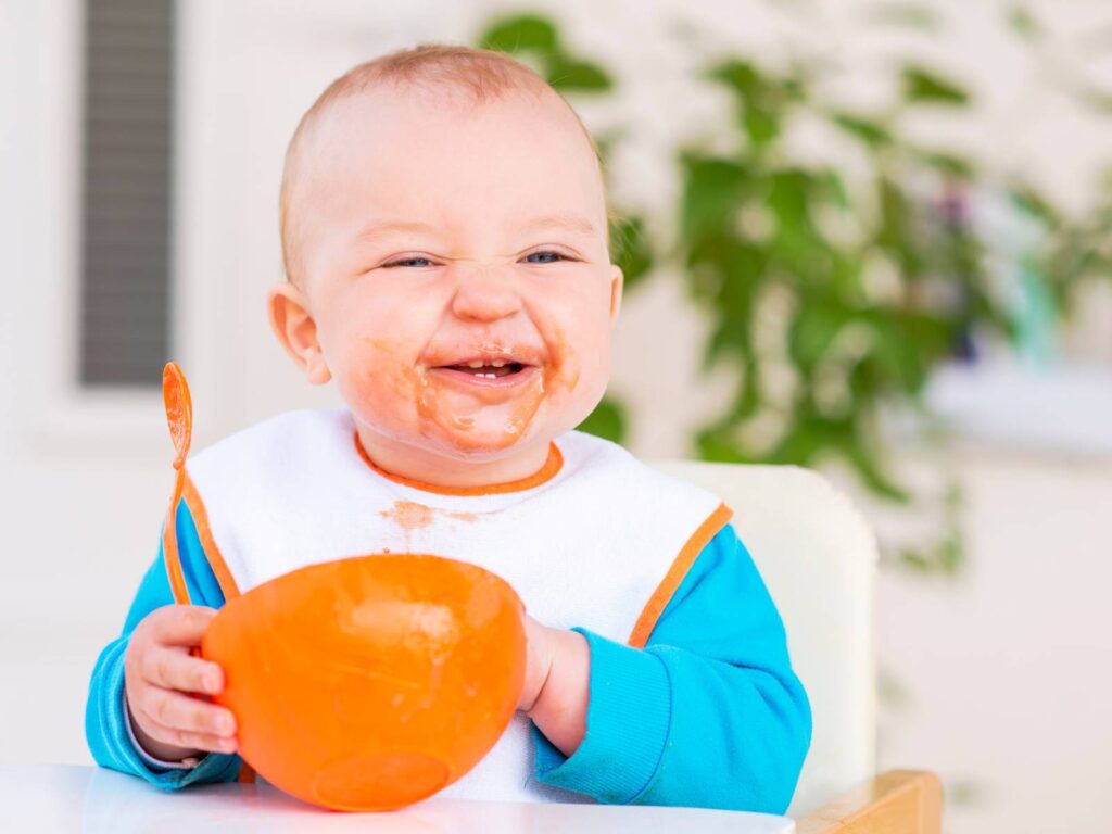 口のまわりを汚しているが、嬉しそうに食べている赤ちゃん